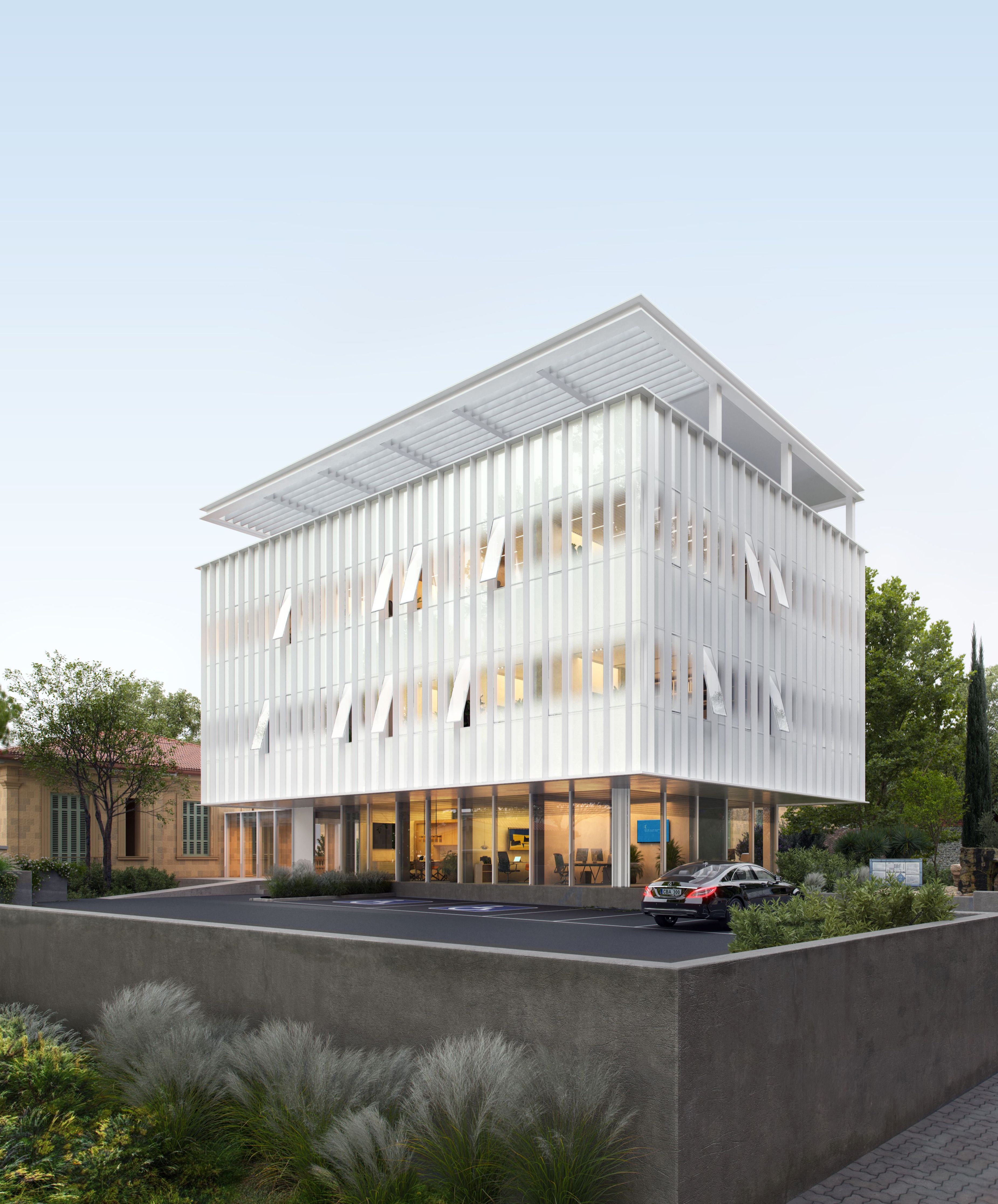 Modern white building with unique louvers and rooftop structure, surrounded by green landscaping.