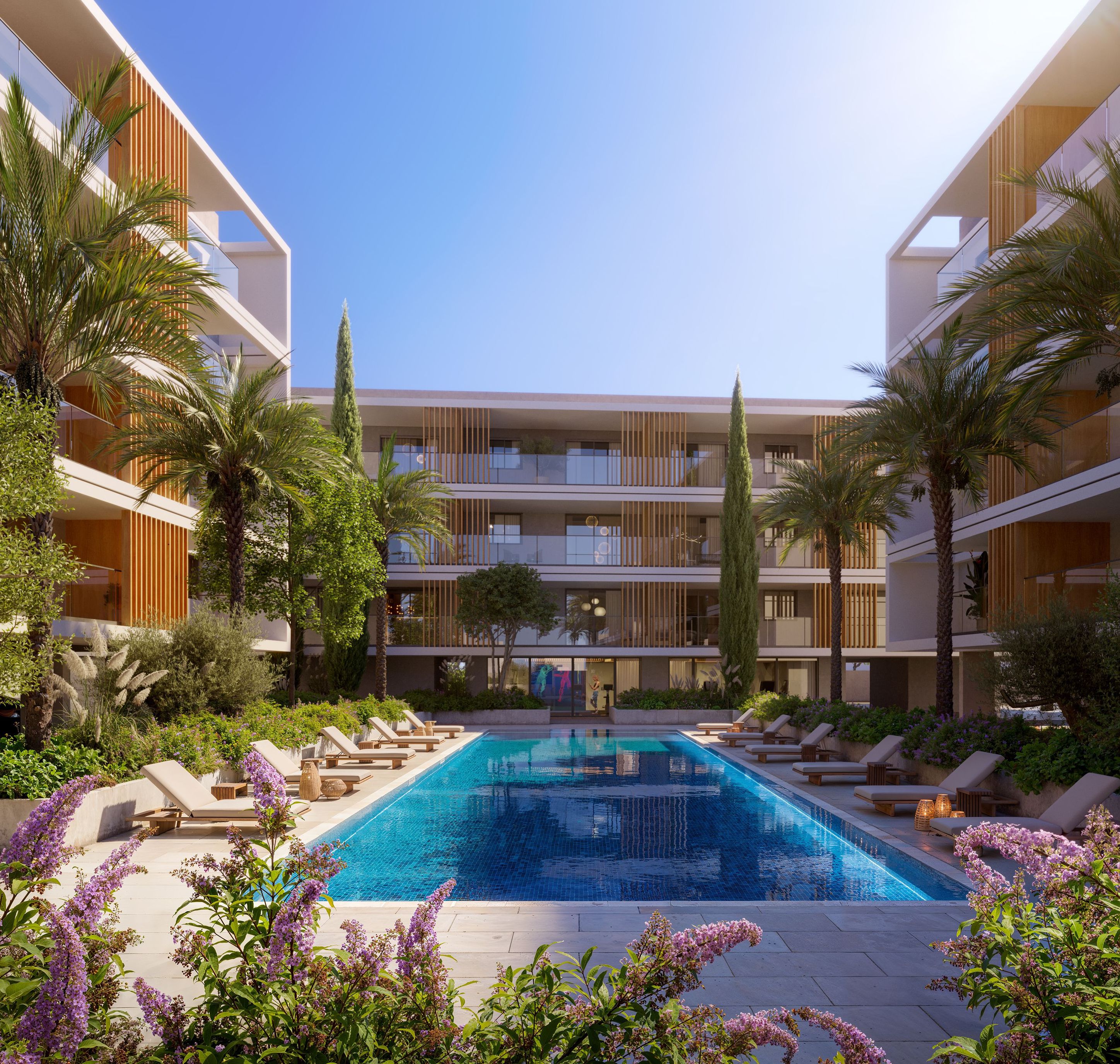 Modern resort-style apartment complex with large swimming pool, palm trees, and elegant landscaping.