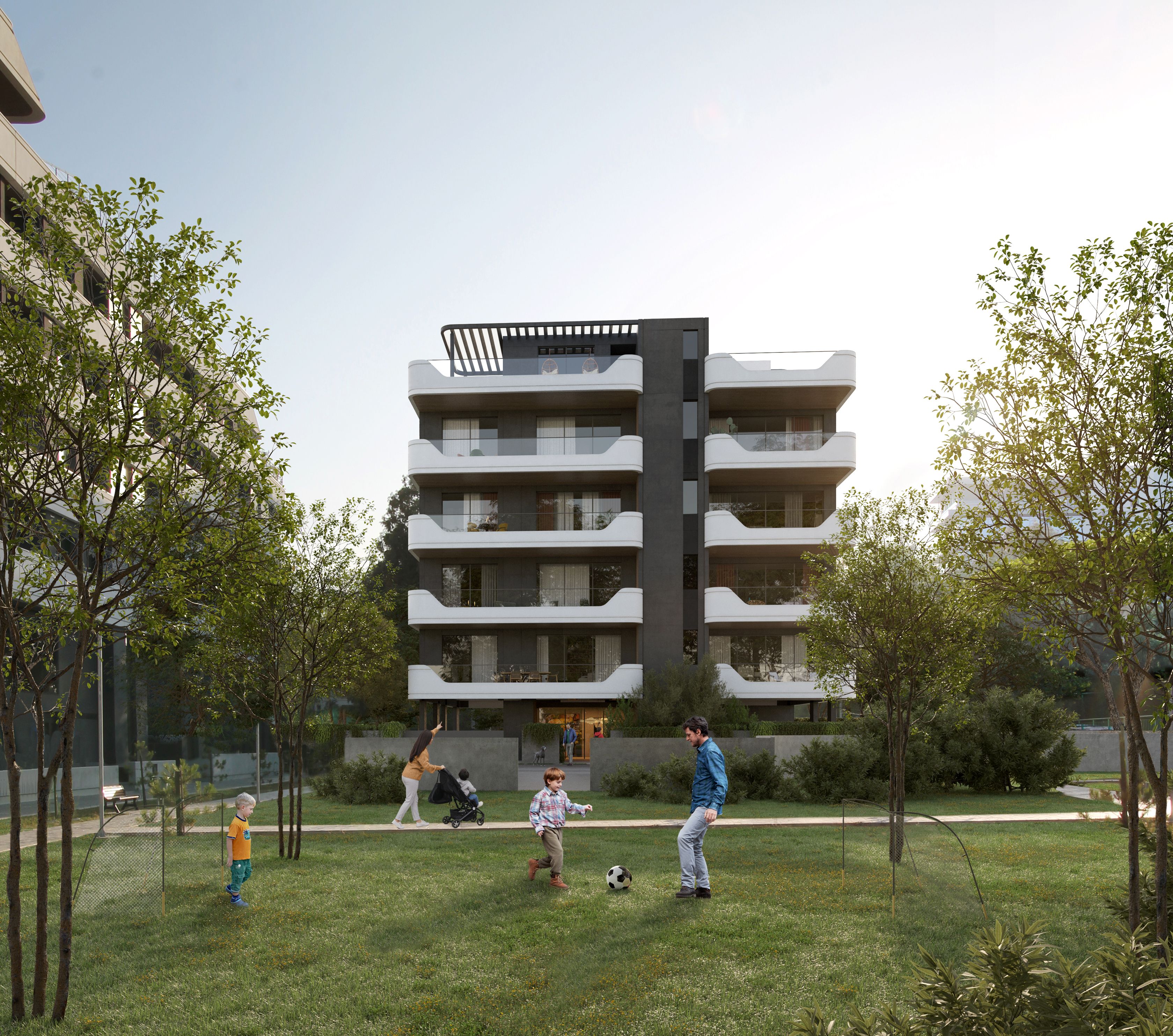 Modern apartment building with white balconies overlooking a green lawn where children play.
