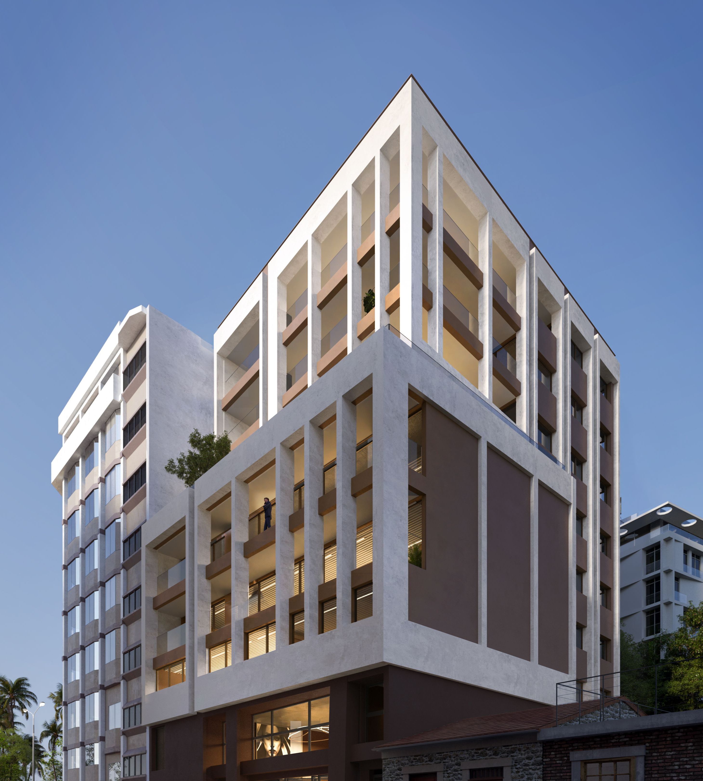 Modern white multi-story building with geometric architectural details against a clear blue sky.
