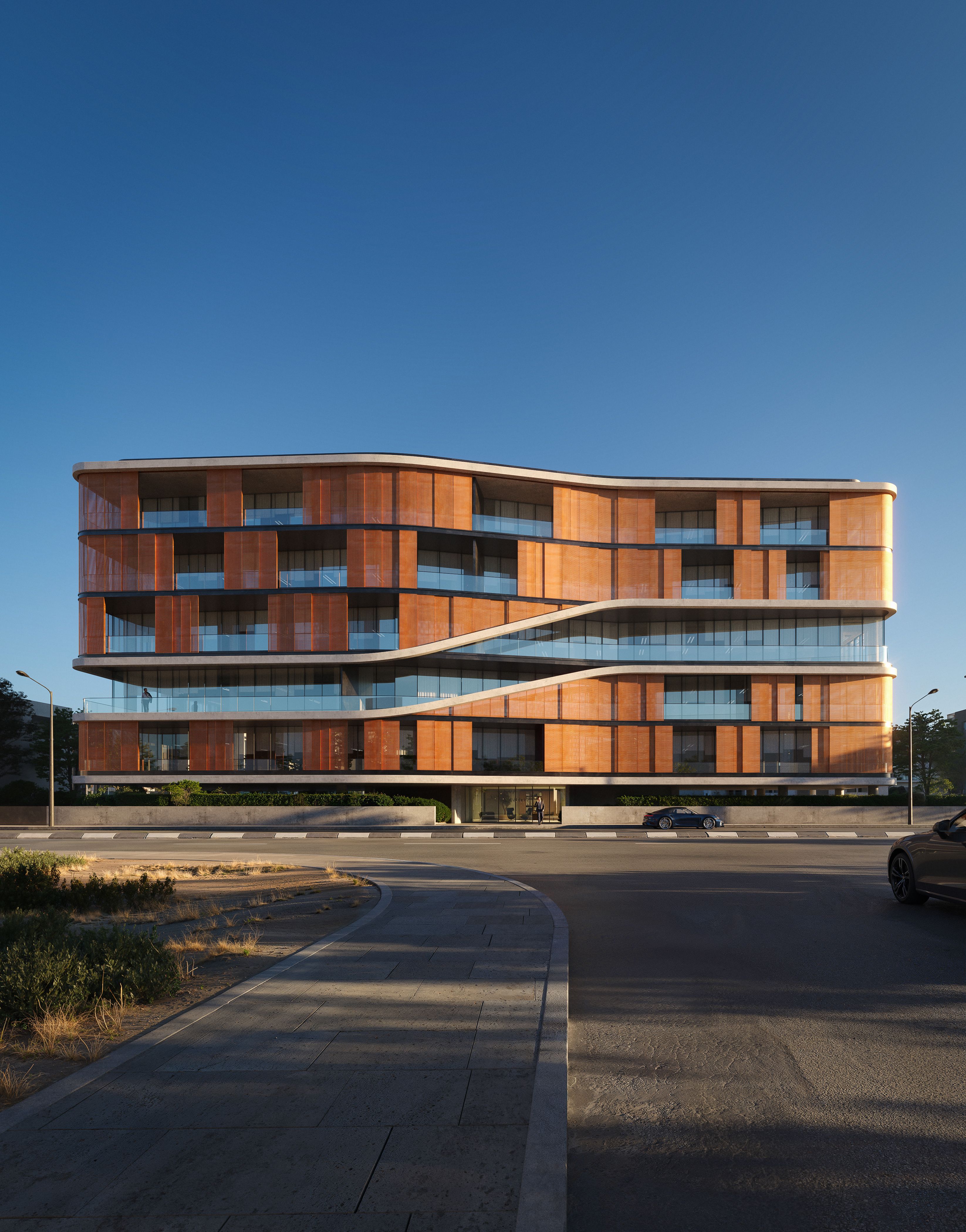 Modern building with curved wooden facades and glass balconies under a clear blue sky.
