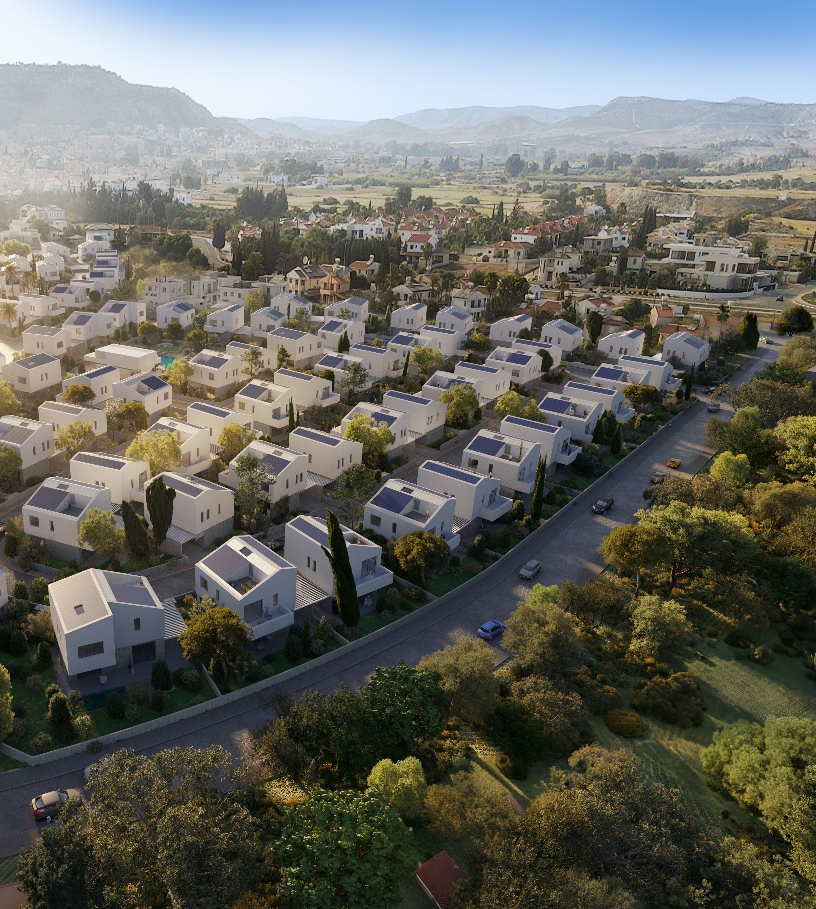 Aerial view of a modern residential development with white houses among green hills.