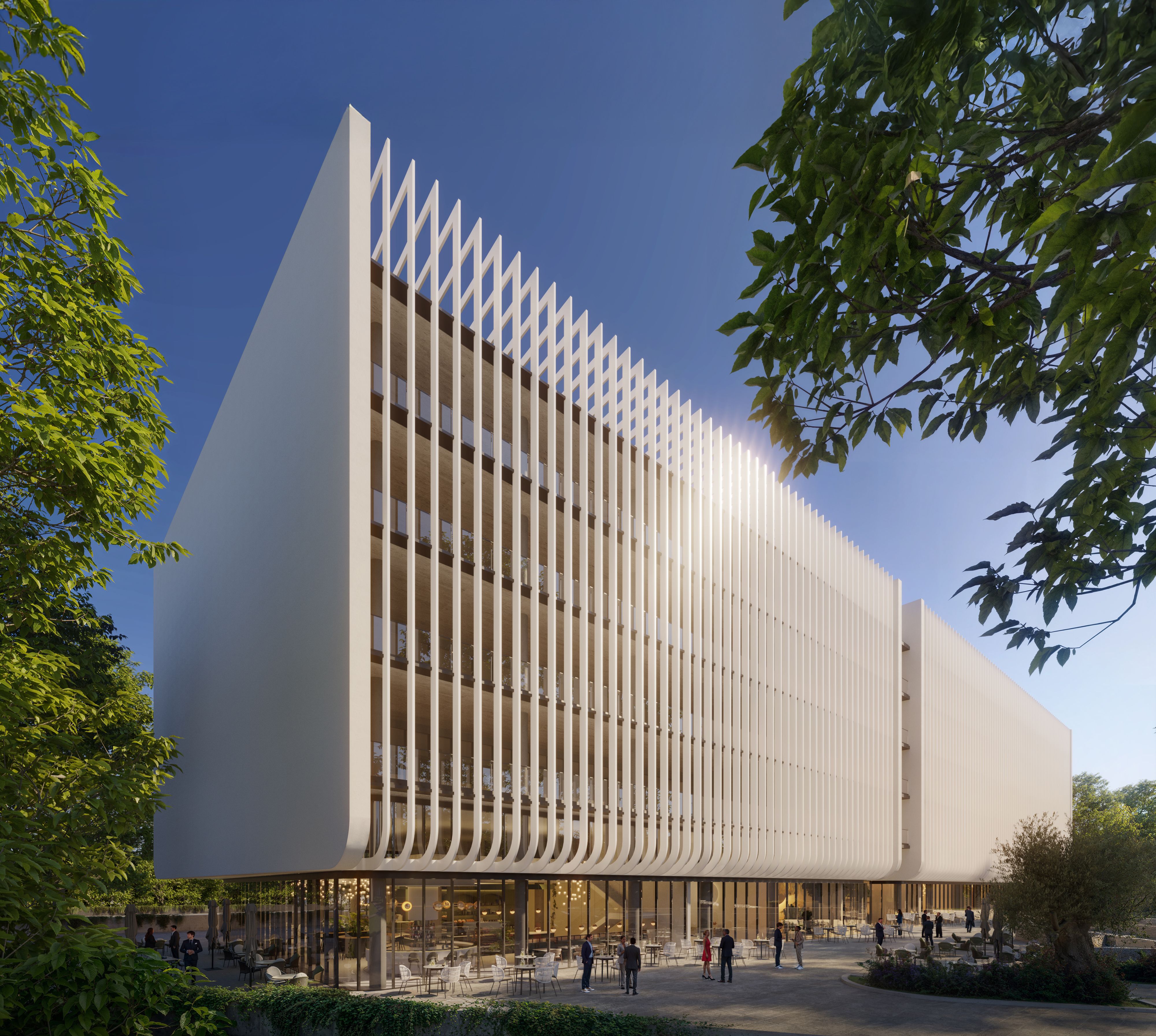 Modern white building with a unique facade of vertical fins under a clear blue sky.