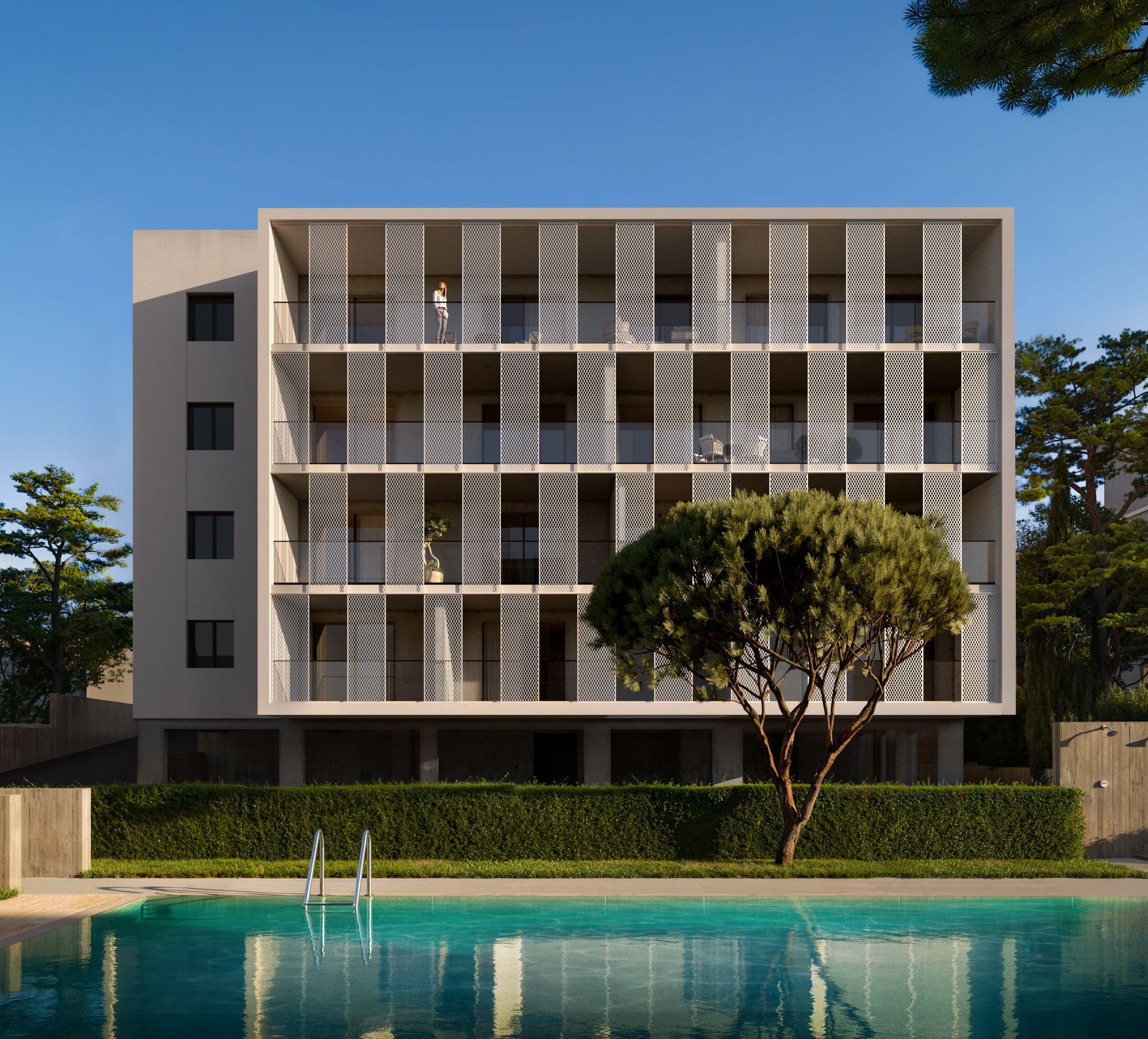Modern hotel building with slatted facade, swimming pool, and green hedge under a clear sky.