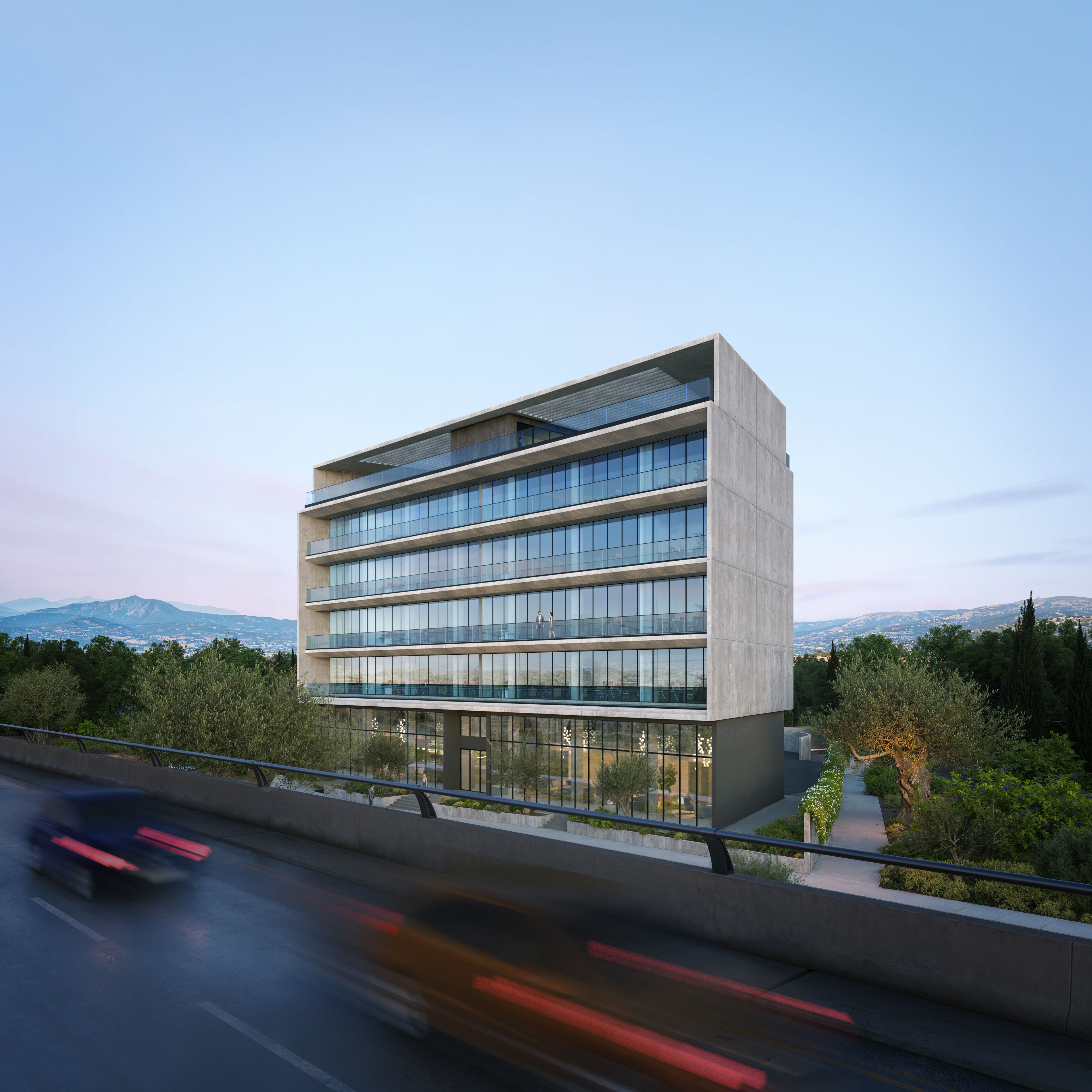 Modern concrete and glass building stands beside a busy road with blurred car lights.