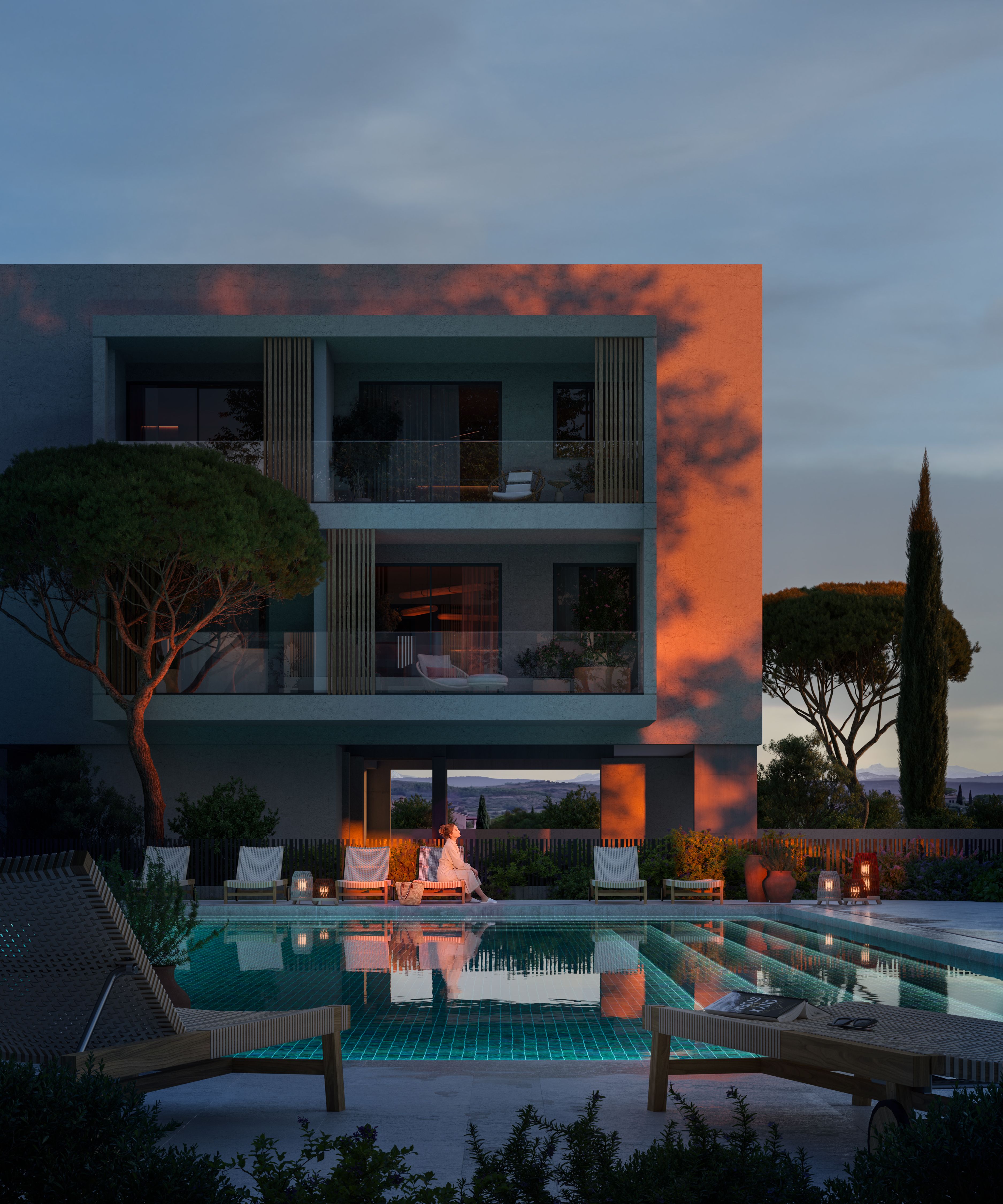 Modern building with balconies and a swimming pool at sunset, reflecting orange light.