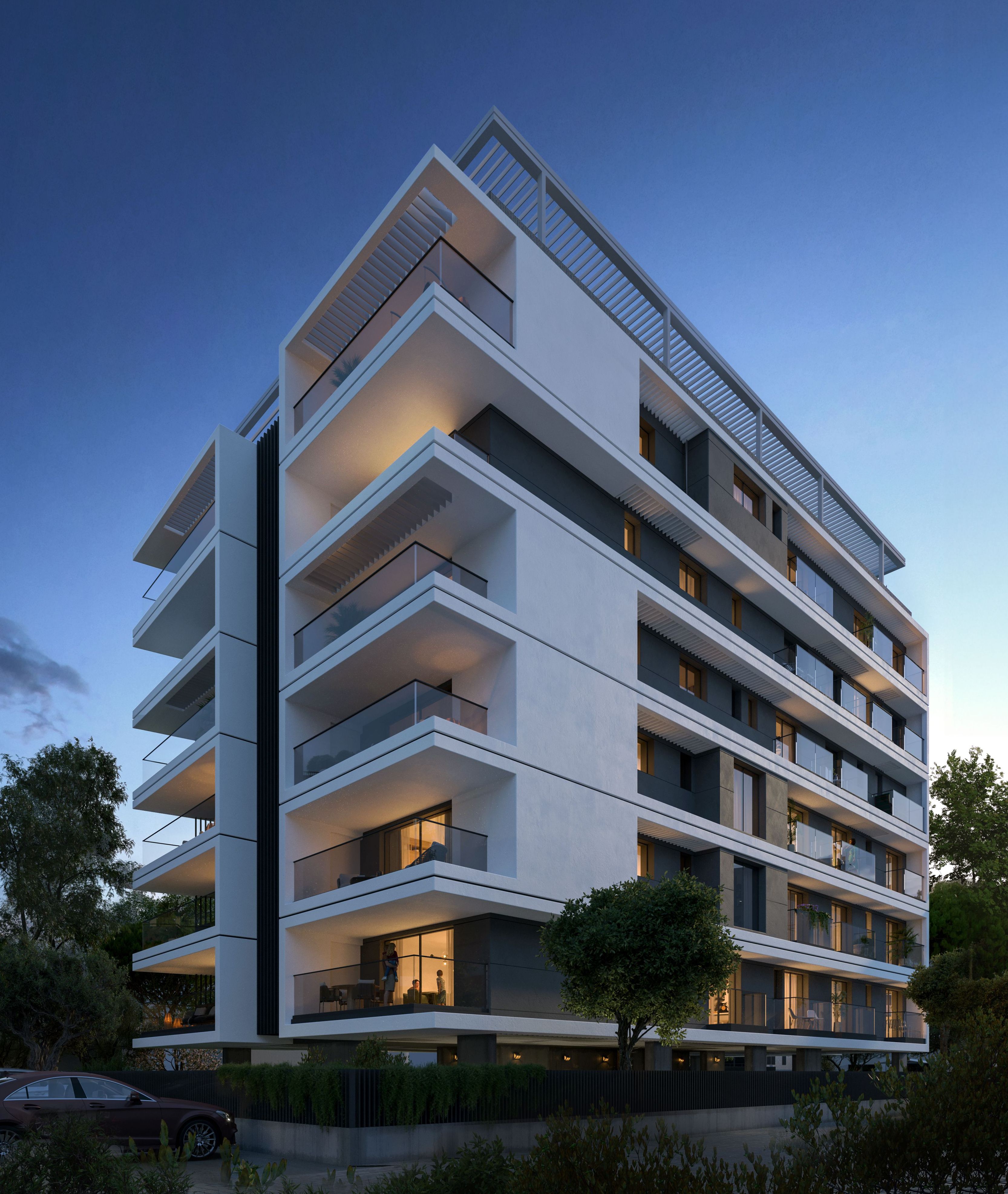 Modern white apartment building with multiple balconies under a deep blue evening sky.