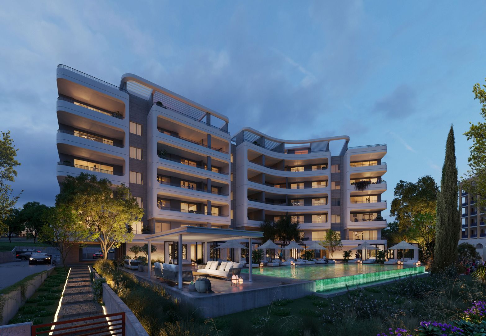 Luxurious modern apartment building at dusk with illuminated balconies and a bright swimming pool.
