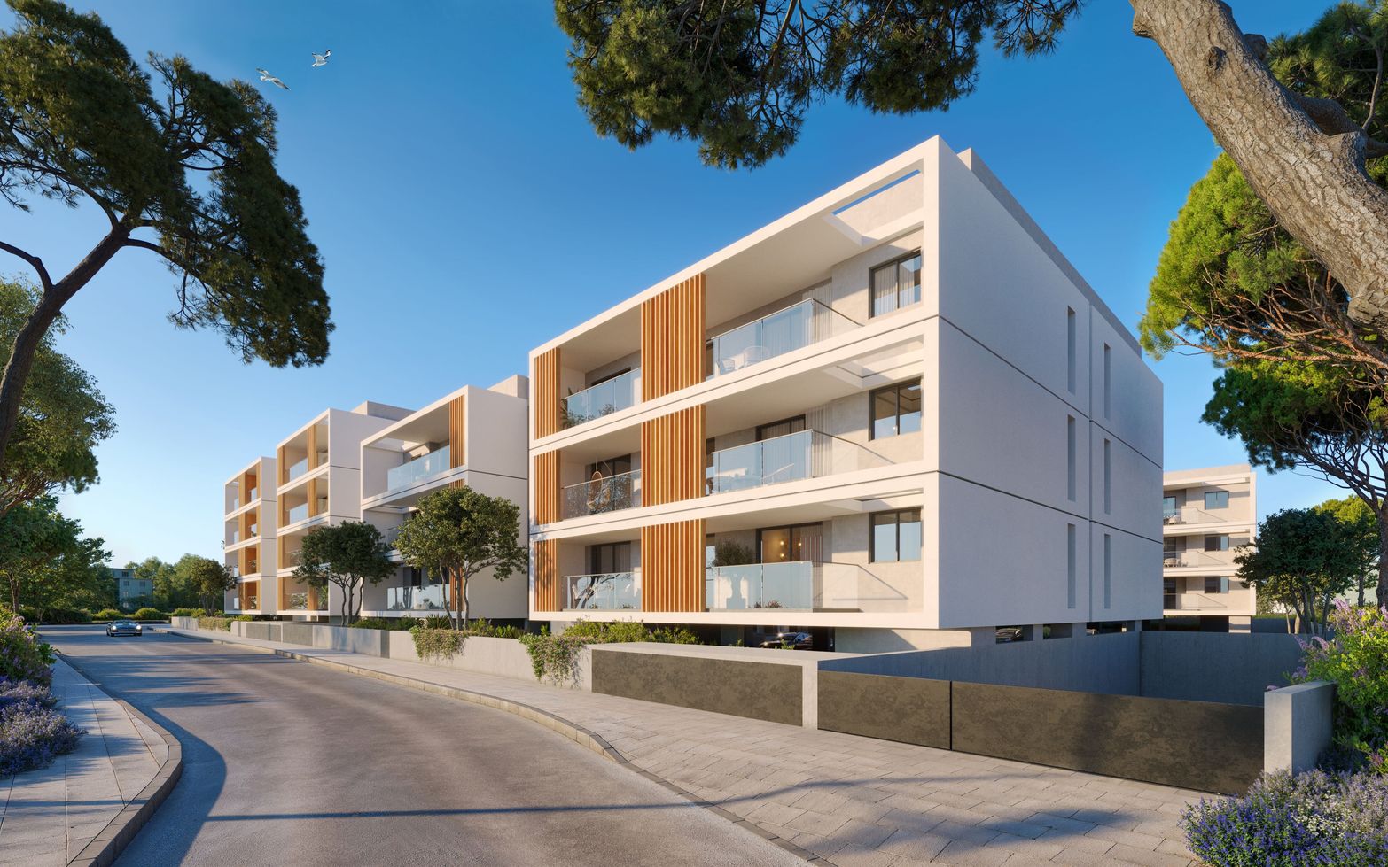 Modern apartment buildings with white facades, wooden accents, and balconies under a clear sky.