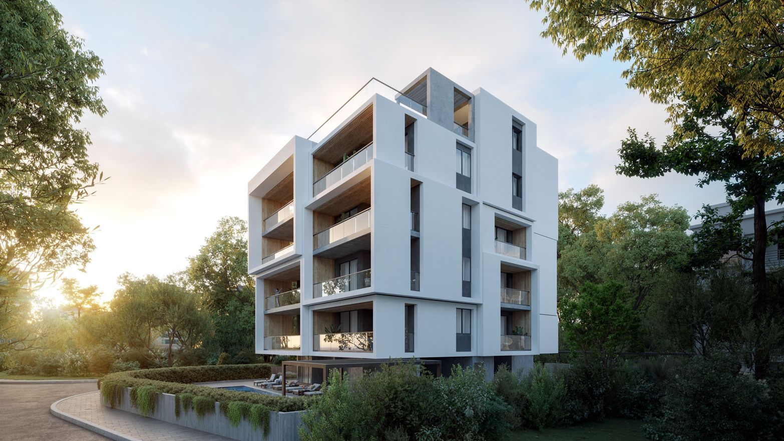 Modern white multi-story building with balconies surrounded by lush green trees at sunset.