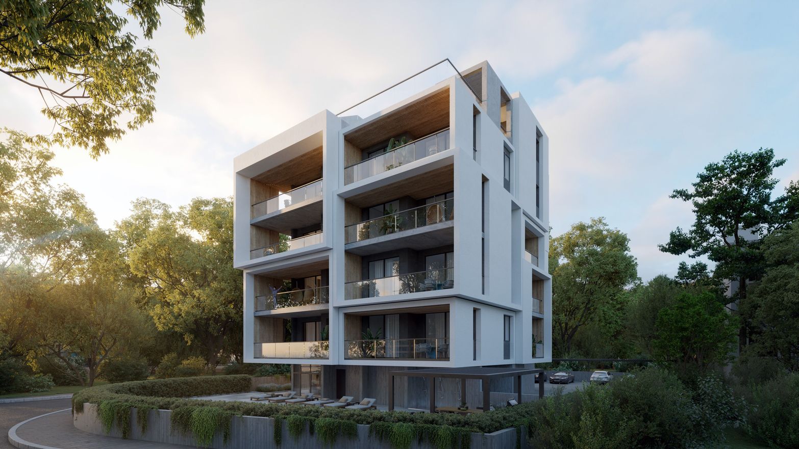 Modern white building with multiple balconies surrounded by green trees under a bright sky.