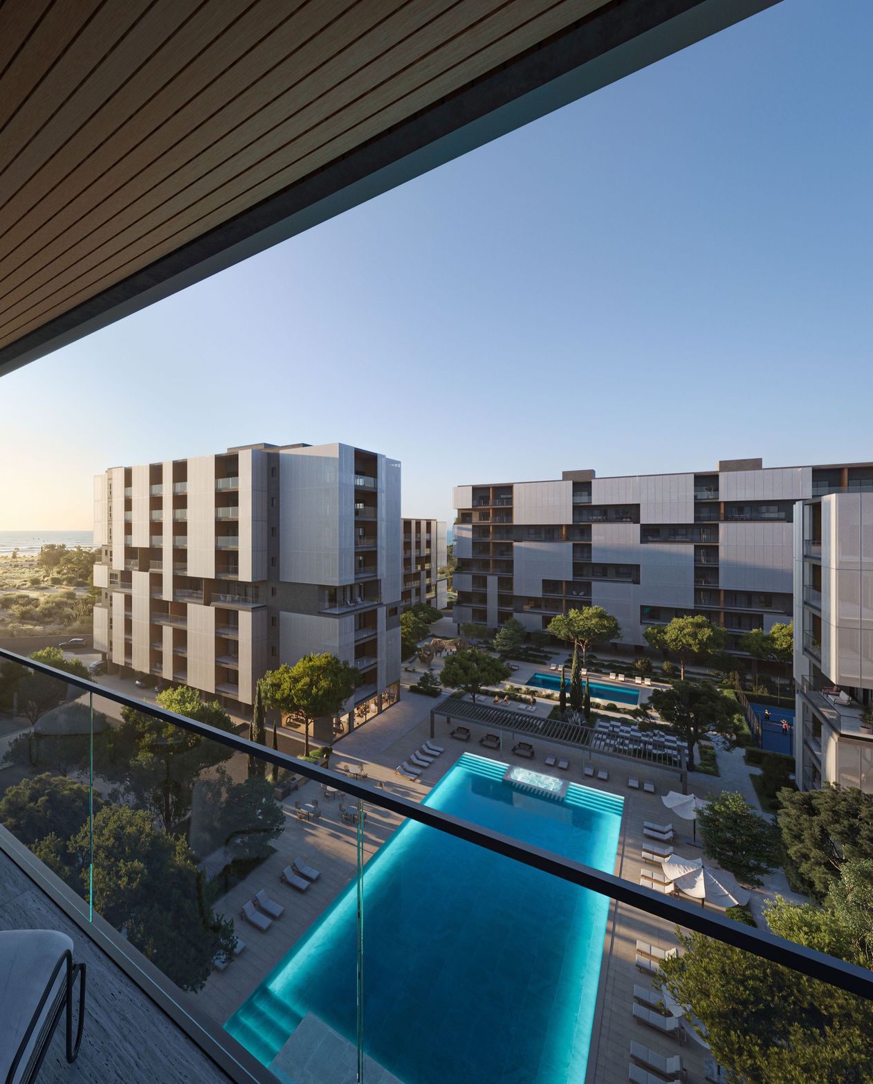 A high-angle view of modern buildings, a large blue swimming pool, and landscaping.