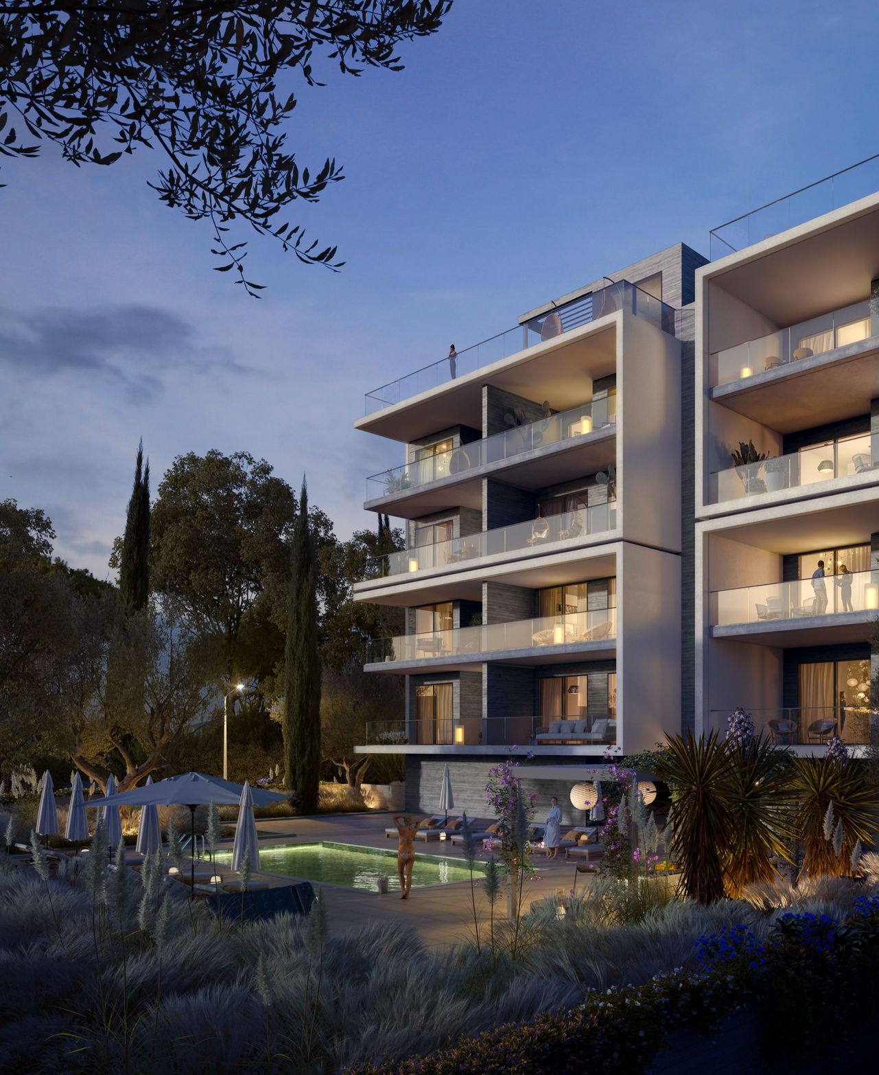 Modern apartment building with illuminated balconies and an outdoor garden area at dusk.