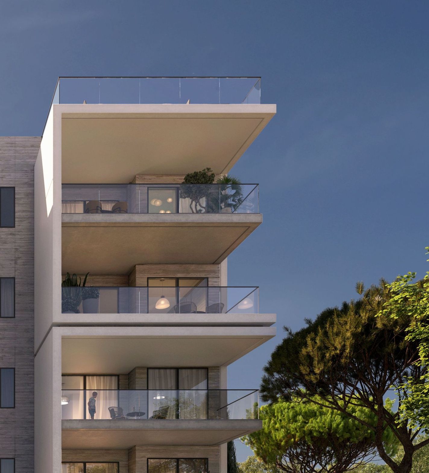 Modern building with three levels of balconies, glass railings, and green trees against a blue sky.