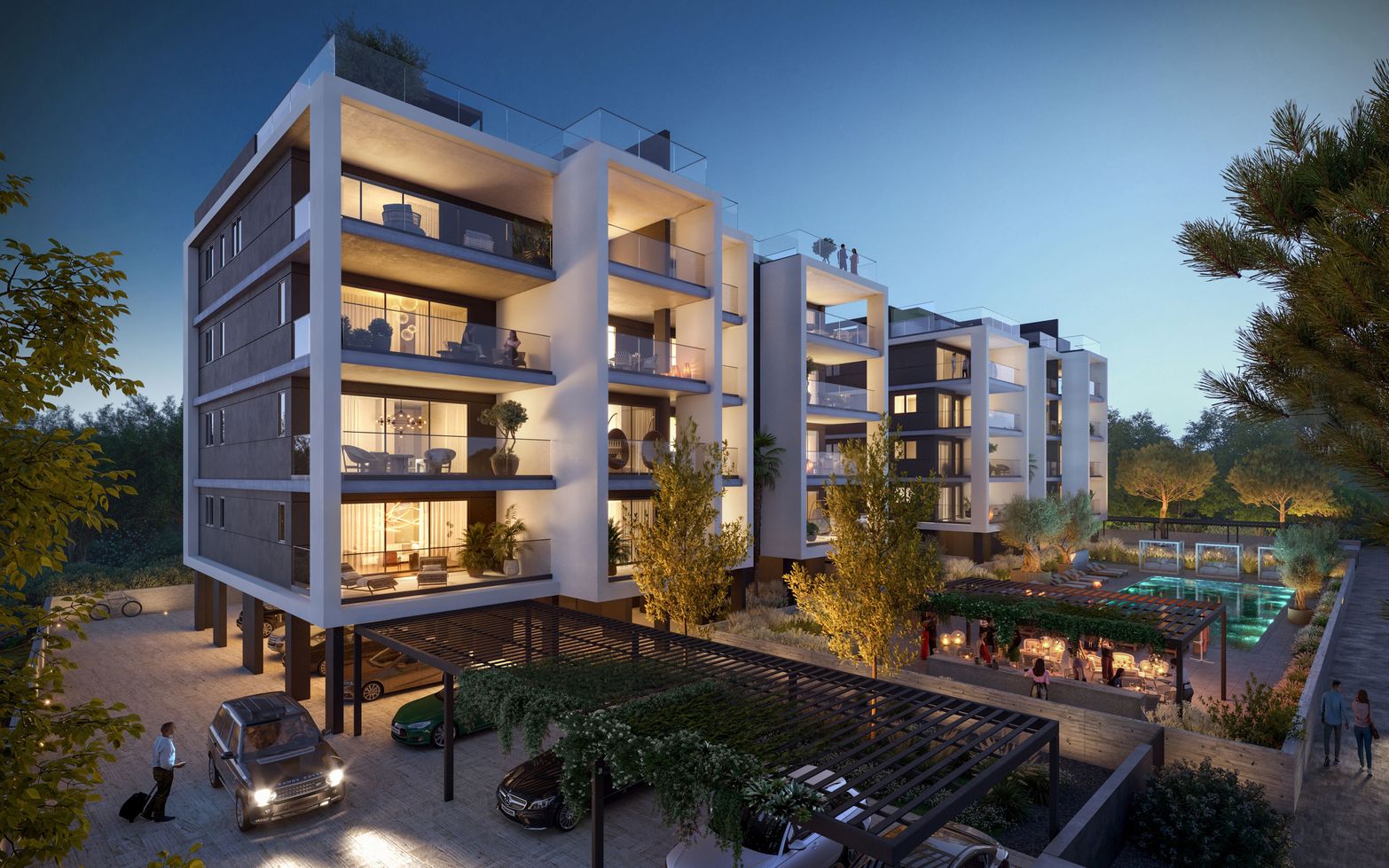 Modern apartment building illuminated at dusk with balconies, a parking area, and a pool.
