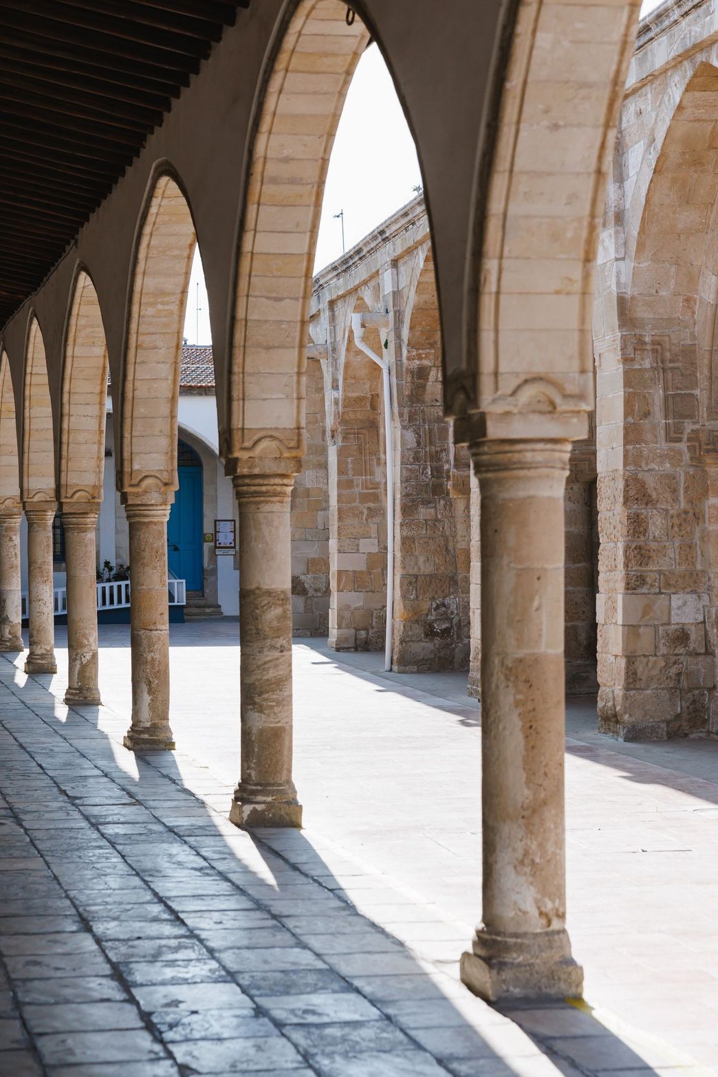 Historic colonnade with light and shadow playing on ancient stone architecture.